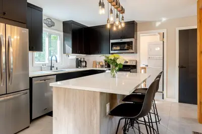 a kitchen with a white counter and black cabinets at Modern Rustic Escape w/Hot Tub - High Falls Lodge in Saugerties
