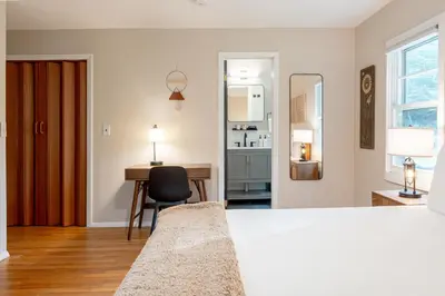 a bedroom with a bed and a desk with a chair at Modern Rustic Escape w/Hot Tub - High Falls Lodge in Saugerties