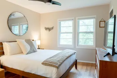 a bedroom with a bed and a mirror at Modern Rustic Escape w/Hot Tub - High Falls Lodge in Saugerties