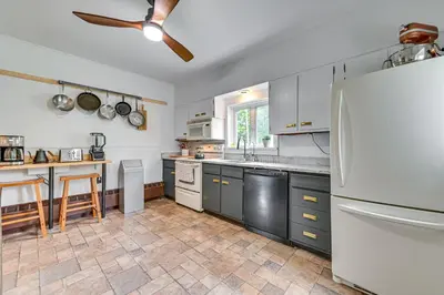 a kitchen with gray cabinets and a white refrigerator at Family Home with Yard and Fire Pit in Middleburgh! in Middleburgh
