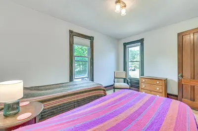 a bedroom with a bed and a dresser and two windows at Family Home with Yard and Fire Pit in Middleburgh! in Middleburgh
