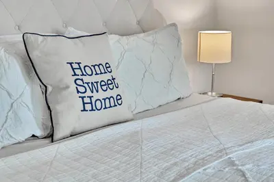 a bed with a pillow with the words home sweet home at Saratoga Guest House in Saratoga Springs