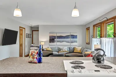 a kitchen and living room with a stove and a couch at Saratoga Guest House in Saratoga Springs