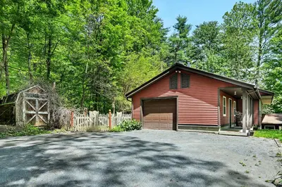 a red house with a garage and a driveway at Saratoga Guest House in Saratoga Springs