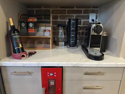 a kitchen counter with a bottle of wine and a phone at NEW! Urban Oasis, Chic 3-BR 2-BA Corner Unit, Steps Away from NYC! in Jersey City
