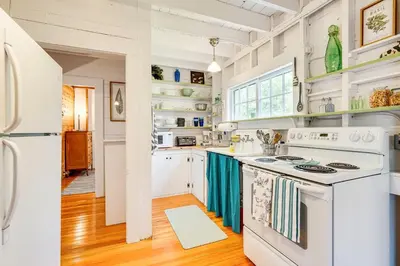 a kitchen with white appliances and wooden floors at 8 Mi to Mount Snow Rustic Marlboro Cottage in Brattleboro