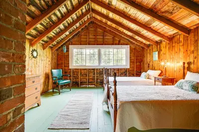 a bedroom with two beds and a window in a barn at 8 Mi to Mount Snow Rustic Marlboro Cottage in Brattleboro