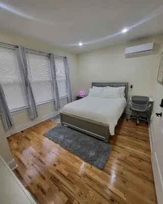 a bedroom with a bed and wooden floors and windows at OoohLaLa! 2 Beds and 2 Full Baths w/Free Parking in Newark