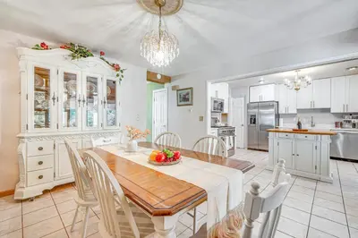a kitchen with a wooden table and a dining room at French-Inspired Townhome 9 Mi to Saratoga Springs! in Malta