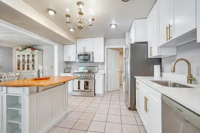 a kitchen with white cabinets and a large island at French-Inspired Townhome 9 Mi to Saratoga Springs! in Malta
