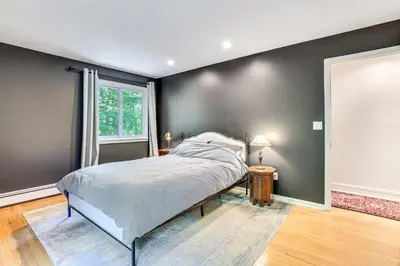 a bedroom with a large bed and a window at Cozy Woodland Home! Ski and Hike Coastal Connecticut in Killingworth