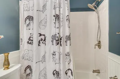 a bathroom with a shower curtain with animals on it at Cozy Woodland Home! Ski and Hike Coastal Connecticut in Killingworth