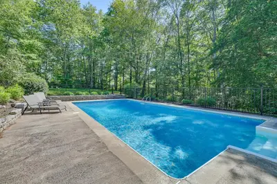 a swimming pool in the backyard of a home at Cozy Woodland Home! Ski and Hike Coastal Connecticut in Killingworth