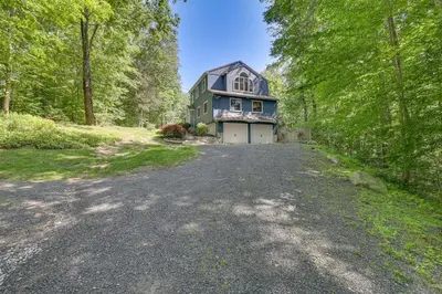 an empty road in front of a house at Cozy Woodland Home! Ski and Hike Coastal Connecticut in Killingworth
