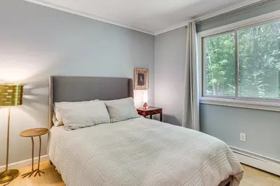 a bedroom with a large bed and a window at Cozy Woodland Home! Ski and Hike Coastal Connecticut in Killingworth