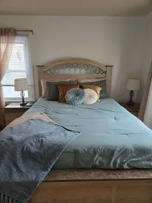 a bed with a blue comforter and pillows on it at House in New Jersey in Paterson
