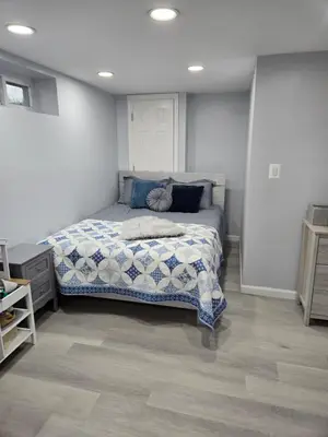 a bedroom with a bed with a blue and white comforter at House in New Jersey in Paterson