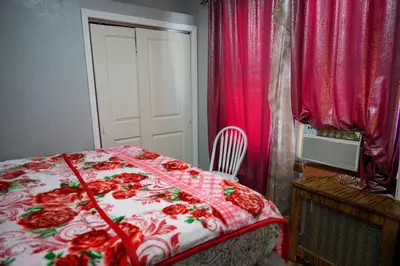 a bedroom with a bed with a red and white blanket at Divine Villa Guest House Harper Ave WITH FREE PRIVATE PARKING in Irvington