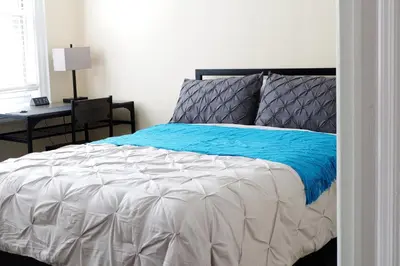 a bedroom with a bed with a blue blanket at Newly Renovated - Minutes from the City in Woodside