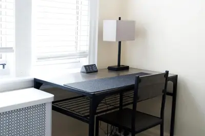 a black desk with a lamp and a chair at Newly Renovated - Minutes from the City in Woodside