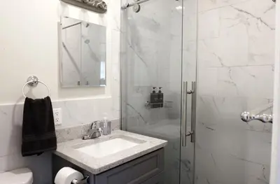a white bathroom with a sink and a shower at Newly Renovated - Minutes from the City in Woodside