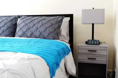 a bedroom with a bed and a nightstand with a lamp at Newly Renovated - Minutes from the City in Woodside