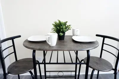 a wooden table with chairs and a plant on it at Newly Renovated - Minutes from the City in Woodside