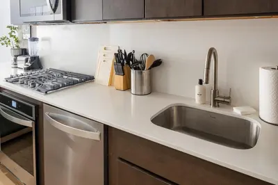 a kitchen counter with a sink and a stove at Luxury Full Floor Chelsea with WasherDryer 2bd in New York