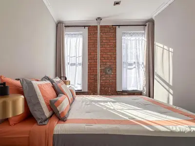 a bedroom with a bed and a brick wall at New York Suite Upper East Side - Manhattan in New York