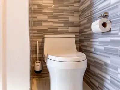 a bathroom with a toilet and a roll of toilet paper at New York Suite Upper East Side - Manhattan in New York