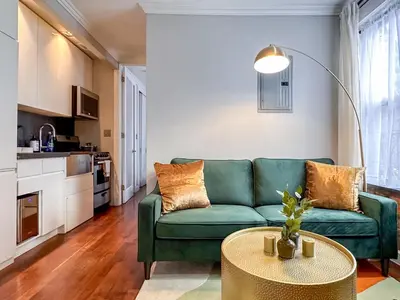a living room with a green couch and a table at New York Suite Upper East Side - Manhattan in New York