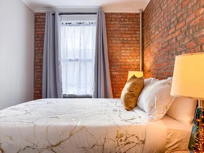 a bedroom with a brick wall and a bed at New York Suite Upper East Side - Manhattan in New York