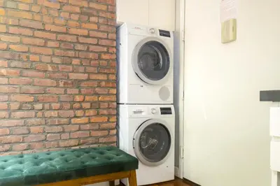 a washer and dryer next to a brick wall at New York Suite Upper East Side Manhattan in New York