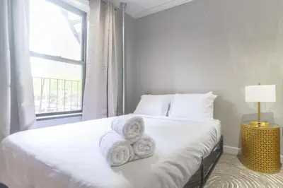 a white bedroom with a bed with towels on it at New York Suite Upper East Side Manhattan in New York
