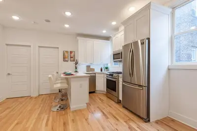a kitchen with white cabinets and a stainless steel refrigerator at Modern & Spacious 3 BED & 2 BA Condo mins from NYC in Jersey City