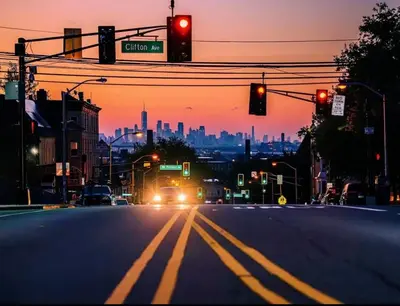a city street with a red traffic light and a city skyline at Harmony in the Heights - Master in Newark