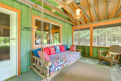 a porch with a swing in a house at Cardinal Pines Cabin on 8 Acres - Dog Friendly! in New Berlin