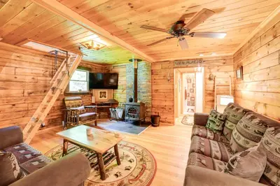 a living room with a couch and a table at Cardinal Pines Cabin on 8 Acres - Dog Friendly! in New Berlin