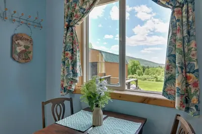 a table with a vase of flowers and a window at Cozy Catskills Studio Rental with Mountain Views! in Stamford
