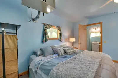 a bedroom with a large bed with blue walls at Cozy Catskills Studio Rental with Mountain Views! in Stamford