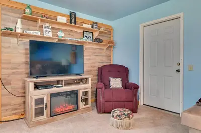 a living room with a fireplace and a television at Cozy Catskills Studio Rental with Mountain Views! in Stamford