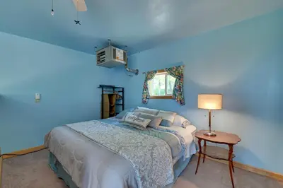 a blue bedroom with a bed and a lamp at Cozy Catskills Studio Rental with Mountain Views! in Stamford