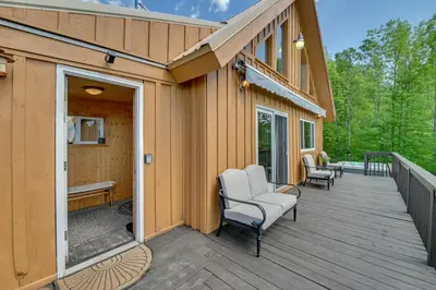 a deck with two chairs and a bench on a house at Catskills Cabin Rental with Hot Tub and Amazing Views! in Stamford