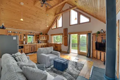 a living room with a couch and chairs in a house at Catskills Cabin Rental with Hot Tub and Amazing Views! in Stamford