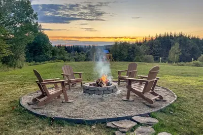 two chairs and a fire pit in a field at Catskills Cabin Rental with Hot Tub and Amazing Views! in Stamford