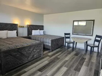 a hotel room with two beds and a table and chairs at Motel 81 in Dalton