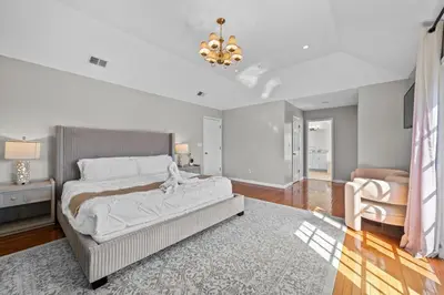 a bedroom with a large bed and a chandelier at Spacious 6 BR Villa - Serene Scenic Mountain Escape in Bloomingburg