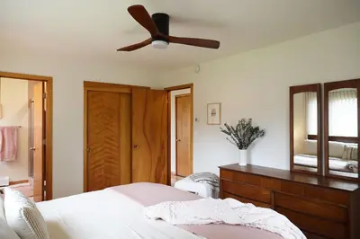 a bedroom with a bed and a ceiling fan at Catskills Retro Retreat- Upstate Home W Hot Tub in Saugerties