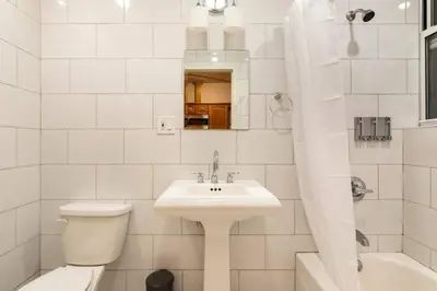 a white bathroom with a toilet and a sink at 9Away in The Bronx in Tremont