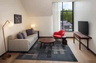 a living room with a couch and a table and a window at The Heartwood in Poughkeepsie